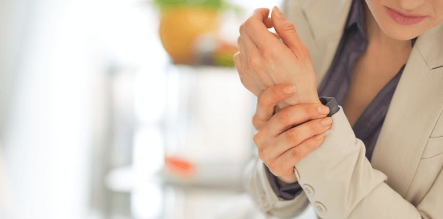 Woman holding her wrist suffering from Chronic Pain
