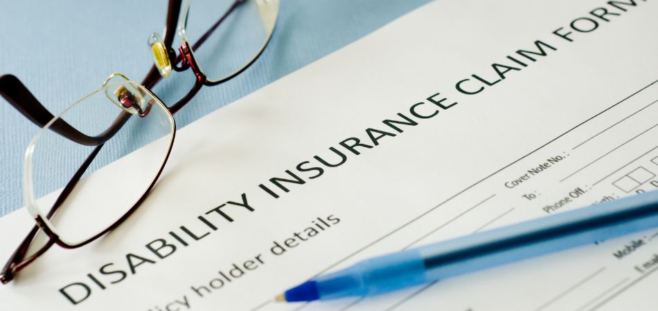 disability insurance claim form with glasses on top
