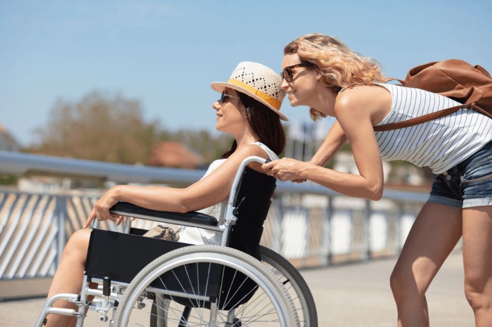 Woman pushing her friend in a wheelchair smiling